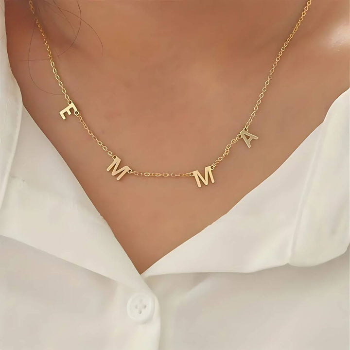 Elegant custom gold necklace with 'Emma' letters, designed for layering or wearing solo for a subtle statement.